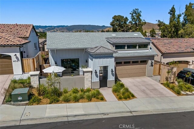 4019 Hillside Dr, San Luis Obispo, CA 93401 - view of front of house featuring board and batten siding, a mountain view, a fenced front yard, concrete driveway, and a gate