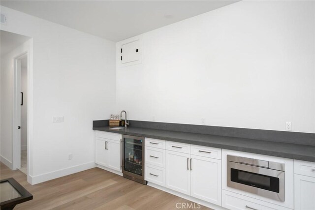 4019 Hillside Dr, San Luis Obispo, CA 93401 - indoor wet bar featuring wine cooler, light wood-style flooring, oven, and electric panel