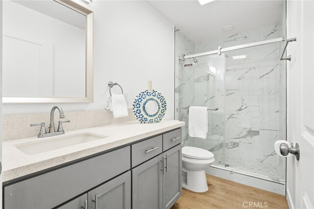500 N Brannick Ave Unit 2, City Terrace, CA 90063 - full bathroom with a marble finish shower, vanity, toilet, and wood finished floors
