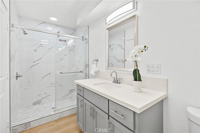 500 N Brannick Ave Unit 2, City Terrace, CA 90063 - bathroom with a marble finish shower, vanity, toilet, and wood finished floors