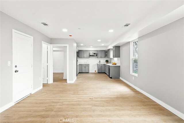 500 N Brannick Ave Unit 2, City Terrace, CA 90063 - kitchen with gray cabinetry, stainless steel microwave, baseboards, recessed lighting, and light wood-style floors