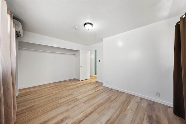3206 4th St, Clearlake, CA 95422 - unfurnished bedroom featuring a wall mounted AC, light wood finished floors, baseboards, and a closet