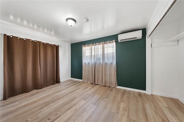 3206 4th St, Clearlake, CA 95422 - spare room featuring a wall mounted AC, light wood-style flooring, and baseboards