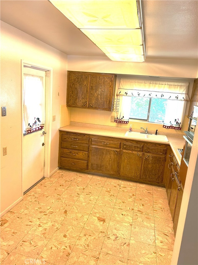 28711 Del Monte Dr, Menifee, CA 92586 - kitchen with a sink, light countertops, and brown cabinetry