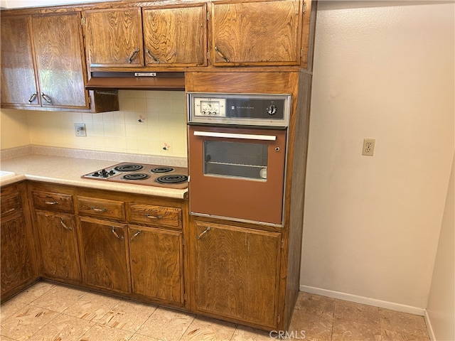 28711 Del Monte Dr, Menifee, CA 92586 - kitchen with electric cooktop, oven, backsplash, light countertops, and baseboards