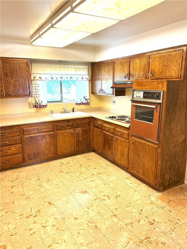 28711 Del Monte Dr, Menifee, CA 92586 - kitchen featuring oven, a sink, light countertops, decorative backsplash, and brown cabinetry