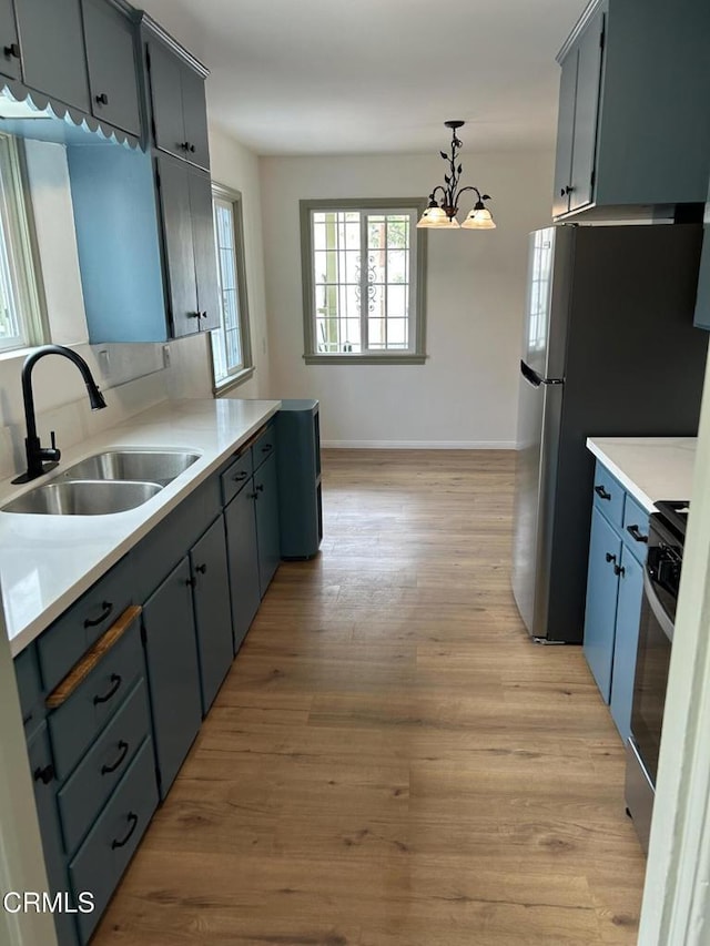 5621 Carlota Blvd, Los Angeles, CA 90042 - kitchen featuring a sink, appliances with stainless steel finishes, a chandelier, light wood-style flooring, and light countertops