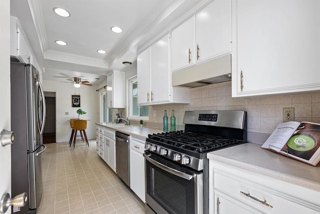 2745 La Gran Via, Carlsbad, CA 92009 - kitchen featuring stainless steel appliances, under cabinet range hood, white cabinetry, light countertops, and ornamental molding