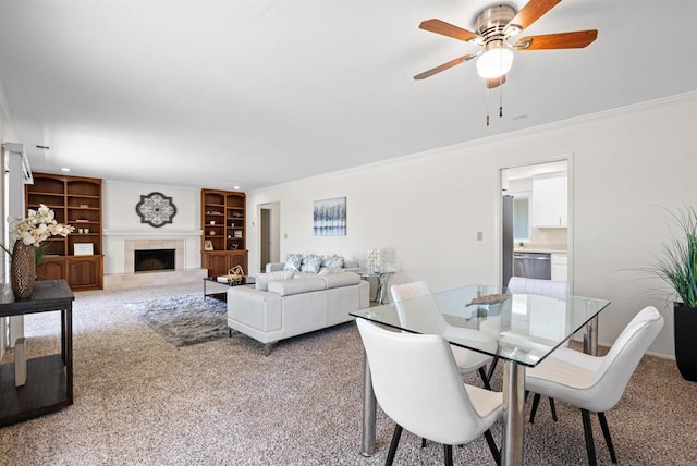 2745 La Gran Via, Carlsbad, CA 92009 - carpeted dining space with built in shelves, ornamental molding, a ceiling fan, and a tiled fireplace