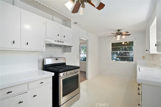 1714 N Towner St, Santa Ana, CA 92706 - kitchen featuring stainless steel range with gas stovetop, under cabinet range hood, ceiling fan, brick wall, and a sink