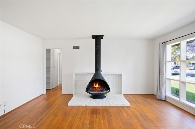 1714 N Towner St, Santa Ana, CA 92706 - unfurnished living room featuring wood finished floors, a wood stove, and baseboards