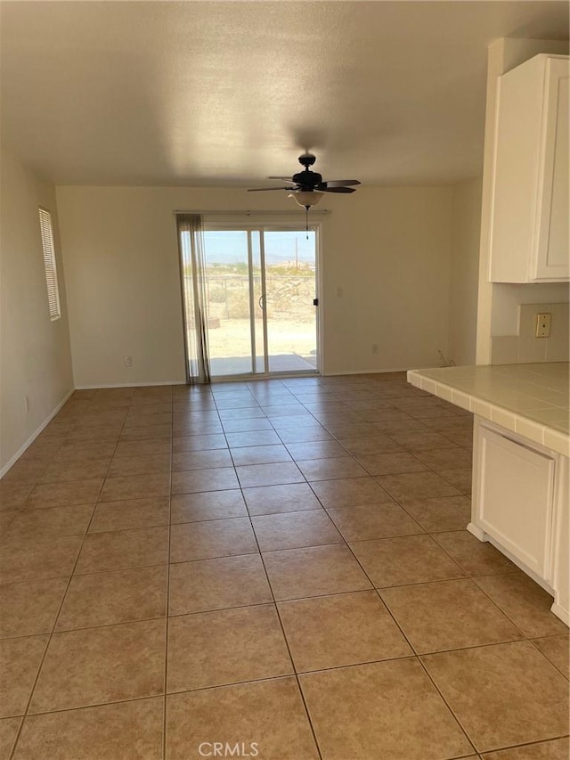 7078 Sheridan Ave Unit 29, Palms, CA 92277 - spare room with a ceiling fan, light tile patterned floors, and baseboards
