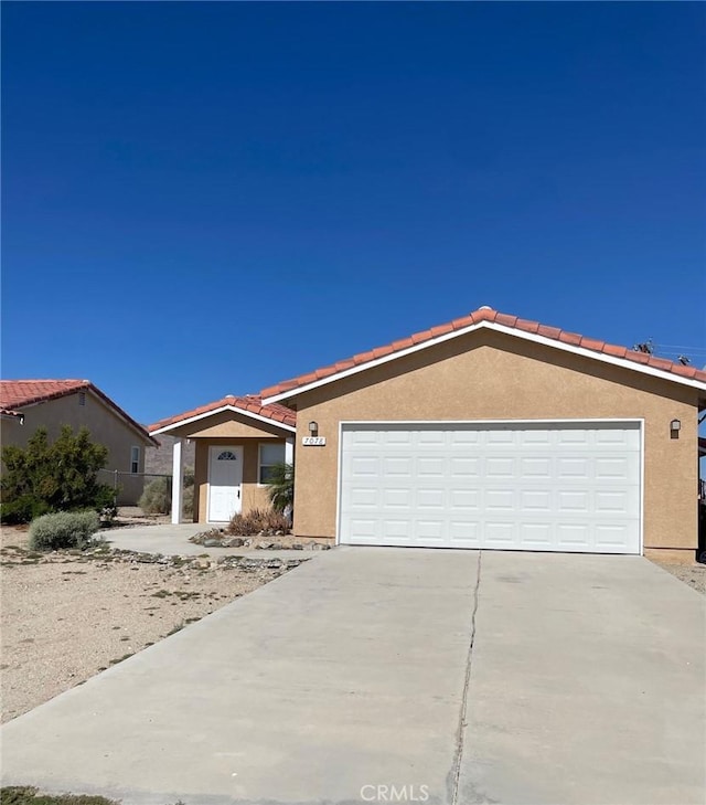 7078 Sheridan Ave Unit 29, Palms, CA 92277 - ranch-style home featuring stucco siding, driveway, a tiled roof, and a garage