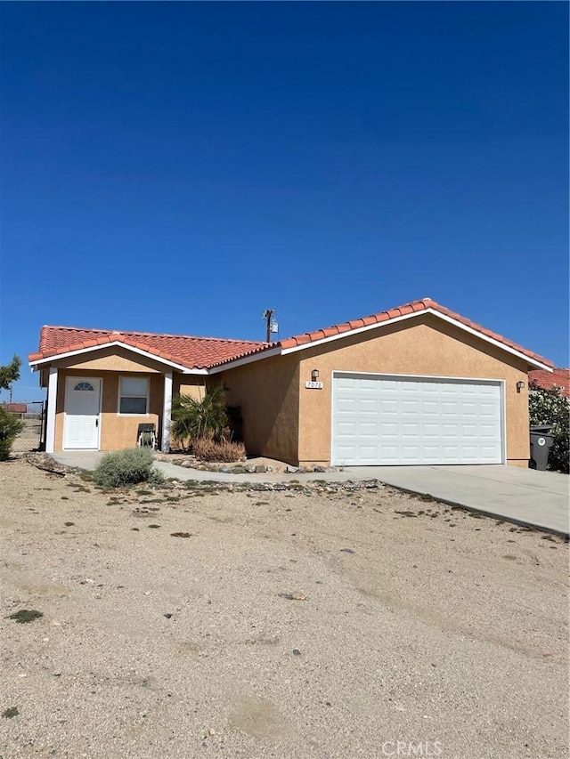 7078 Sheridan Ave Unit 29, Palms, CA 92277 - view of front of house featuring stucco siding, an attached garage, concrete driveway, and a tile roof