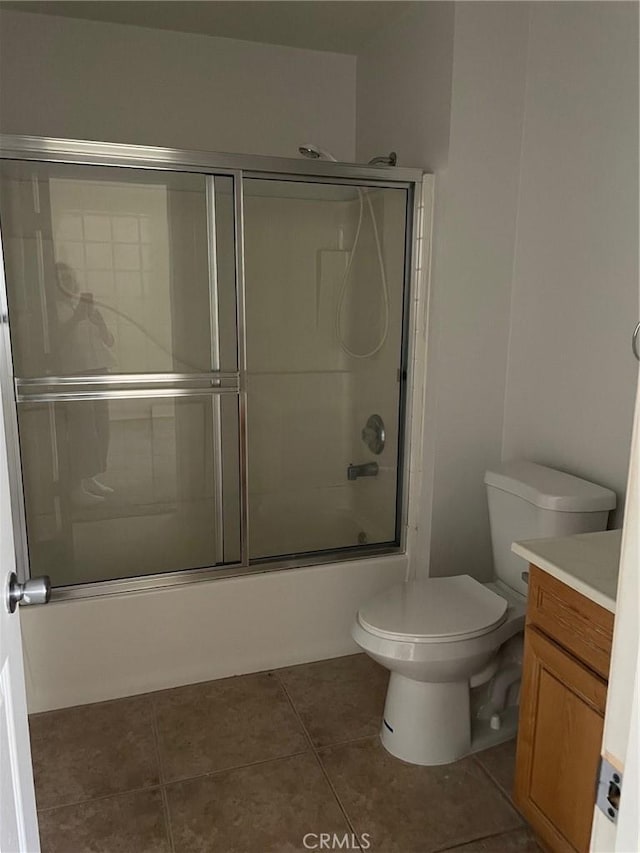 7078 Sheridan Ave Unit 29, Palms, CA 92277 - bathroom featuring vanity, toilet, bath / shower combo with glass door, and tile patterned floors