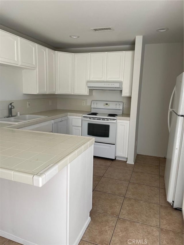7078 Sheridan Ave Unit 29, Palms, CA 92277 - kitchen featuring white appliances, under cabinet range hood, a sink, tile counters, and white cabinetry