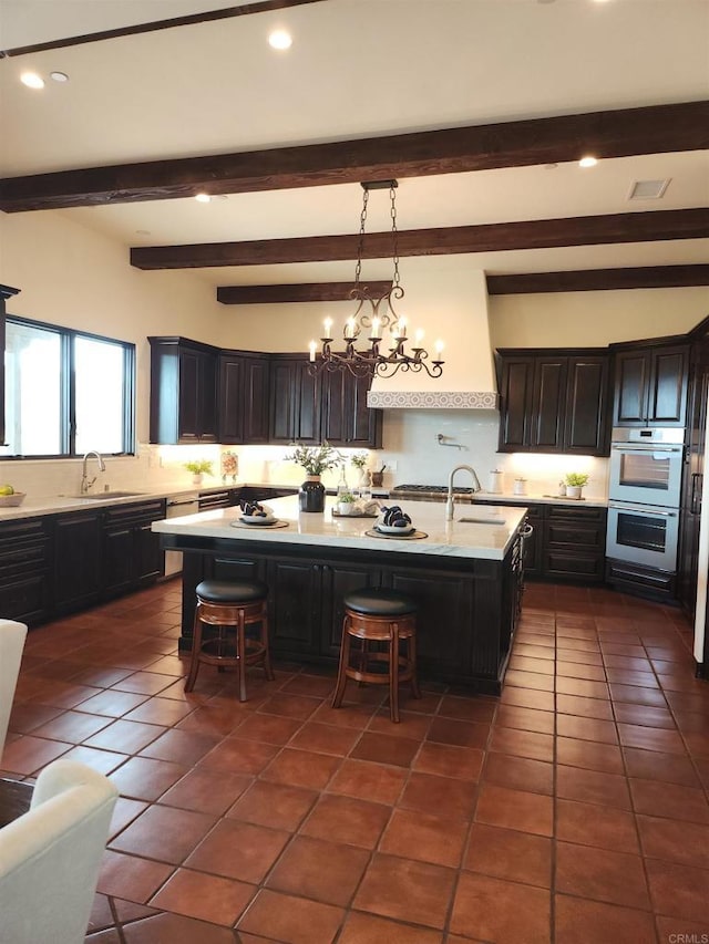 1010 Willowcreek Ln, Fallbrook, CA 92028 - kitchen with a kitchen bar, tasteful backsplash, a center island with sink, dark tile patterned floors, and light countertops