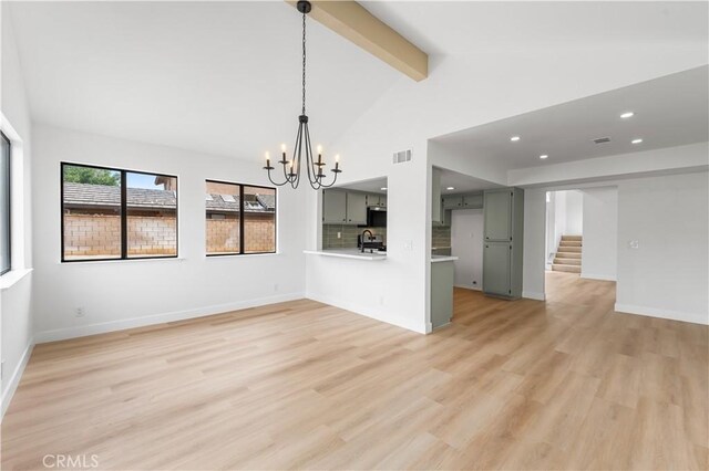 42346 W 47th St W, Lancaster, CA 93536 - unfurnished living room with a sink, a chandelier, beam ceiling, stairs, and light wood-style floors