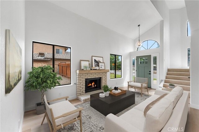 42346 W 47th St W, Lancaster, CA 93536 - living area featuring wood finished floors, high vaulted ceiling, baseboards, stairway, and a brick fireplace
