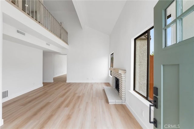 42346 W 47th St W, Lancaster, CA 93536 - unfurnished living room featuring a high ceiling, a fireplace, light wood-style floors, and baseboards