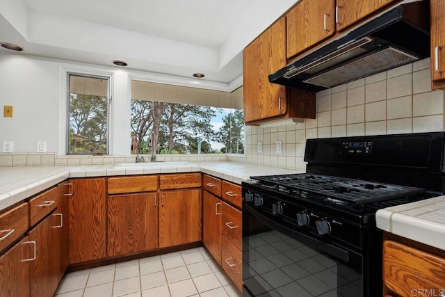 1859 Zapo St, Del Mar, CA 92014 - kitchen with black range with gas stovetop, under cabinet range hood, decorative backsplash, and brown cabinetry