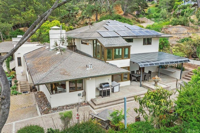 1859 Zapo St, Del Mar, CA 92014 - back of house with stucco siding, roof with shingles, a patio area, roof mounted solar panels, and outdoor dining space