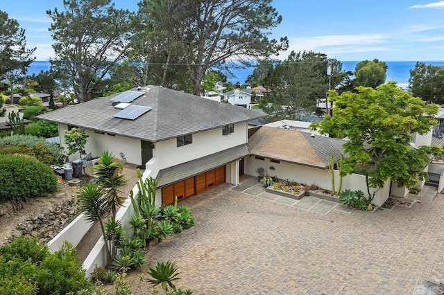 1859 Zapo St, Del Mar, CA 92014 - view of home's exterior featuring stucco siding, roof with shingles, an attached garage, roof mounted solar panels, and a water view