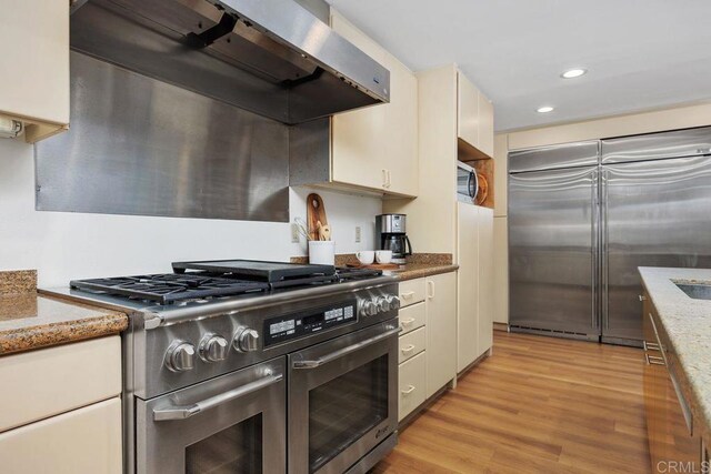 1859 Zapo St, Del Mar, CA 92014 - kitchen featuring high end appliances, exhaust hood, light wood-type flooring, white cabinetry, and recessed lighting