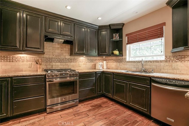 7129 Forbes Ave, Van Nuys, CA 91406 - kitchen with stainless steel appliances, a sink, under cabinet range hood, light wood-style floors, and backsplash