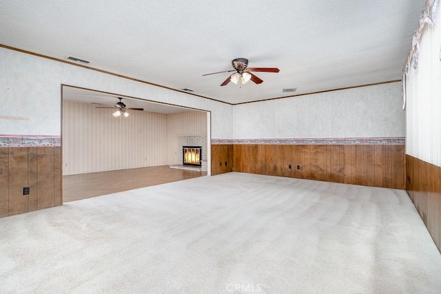 41202 Collegian Way, Hemet, CA 92544 - carpeted spare room with ceiling fan, wooden walls, a wainscoted wall, a fireplace, and ornamental molding