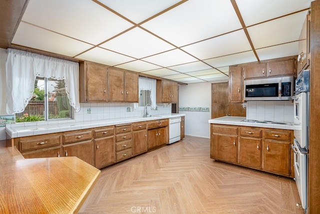 41202 Collegian Way, Hemet, CA 92544 - kitchen featuring white appliances, brown cabinets, backsplash, a sink, and a paneled ceiling