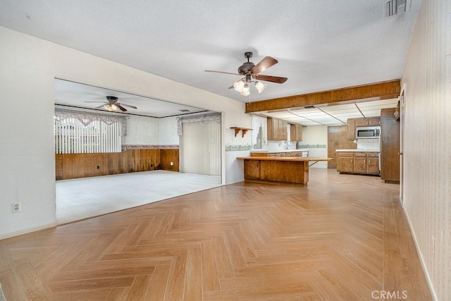 41202 Collegian Way, Hemet, CA 92544 - kitchen featuring ceiling fan, open floor plan, a peninsula, stainless steel microwave, and baseboards