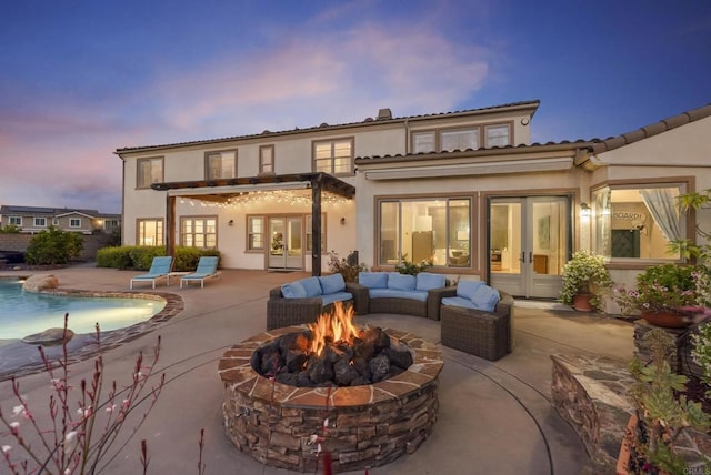 14220 Green Valley Ct, Scripps Miramar, CA 92131 - back of property at dusk with french doors, an outdoor fire pit, and a patio area