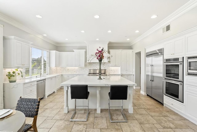 14220 Green Valley Ct, Scripps Miramar, CA 92131 - kitchen with built in appliances, a center island, light countertops, backsplash, and a breakfast bar area