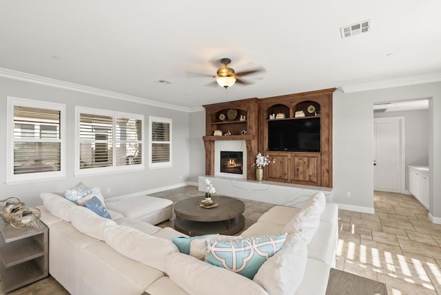 14220 Green Valley Ct, Scripps Miramar, CA 92131 - living room featuring crown molding, stone tile floors, a ceiling fan, a fireplace, and baseboards