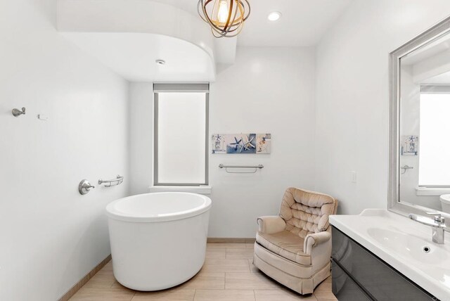 14220 Green Valley Ct, Scripps Miramar, CA 92131 - bathroom with vanity, a freestanding bath, and baseboards