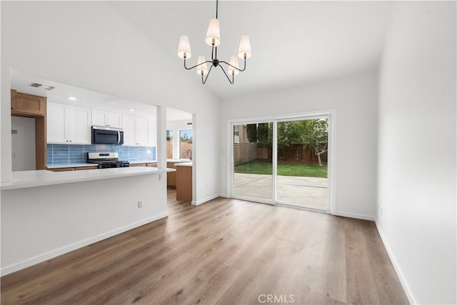 37109 Daisy St, Palmdale, CA 93550 - kitchen with stainless steel appliances, a chandelier, light countertops, light wood-style floors, and decorative backsplash