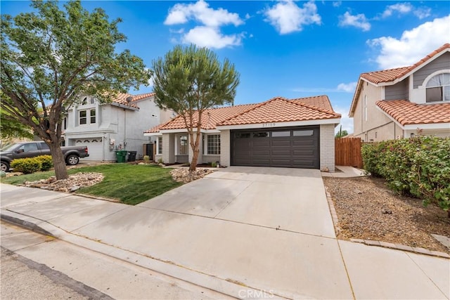 37109 Daisy St, Palmdale, CA 93550 - mediterranean / spanish home with a tiled roof, a garage, driveway, brick siding, and stucco siding