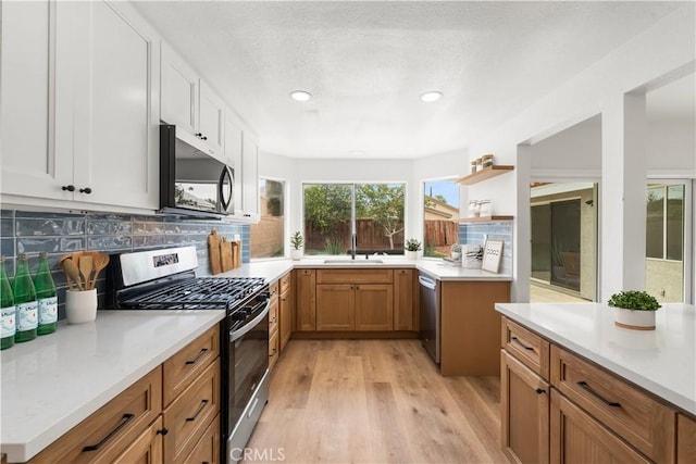 37109 Daisy St, Palmdale, CA 93550 - kitchen featuring stainless steel appliances, a sink, light wood-style floors, backsplash, and light countertops