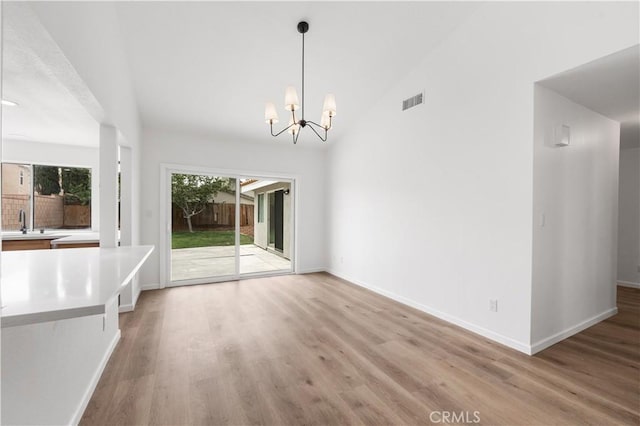 37109 Daisy St, Palmdale, CA 93550 - unfurnished dining area featuring light wood-style flooring, a chandelier, baseboards, a sink, and high vaulted ceiling