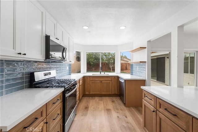 37109 Daisy St, Palmdale, CA 93550 - kitchen with appliances with stainless steel finishes, a sink, light wood-style flooring, backsplash, and light countertops