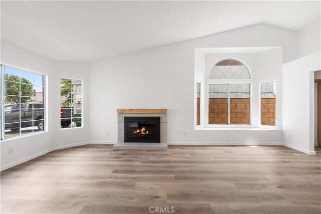 37109 Daisy St, Palmdale, CA 93550 - unfurnished living room featuring a fireplace, wood finished floors, lofted ceiling, and baseboards