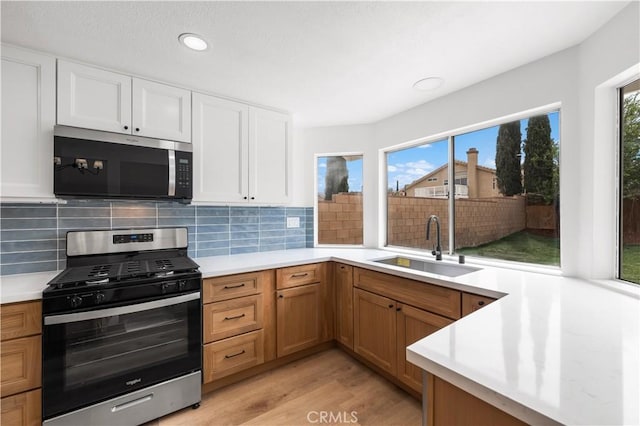 37109 Daisy St, Palmdale, CA 93550 - kitchen featuring appliances with stainless steel finishes, a sink, light countertops, light wood-style flooring, and backsplash