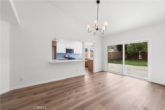 37109 Daisy St, Palmdale, CA 93550 - unfurnished living room featuring a chandelier, wood finished floors, baseboards, and high vaulted ceiling