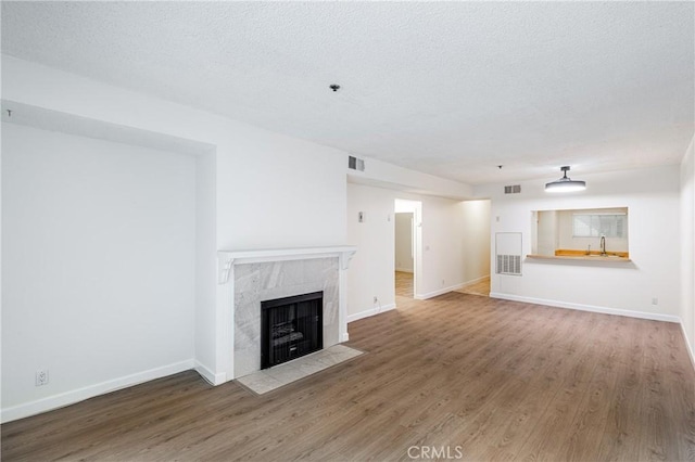2905 Montrose Ave Unit 318, La Crescenta, CA 91214 - unfurnished living room with a tile fireplace, wood finished floors, baseboards, and a textured ceiling