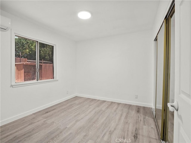 38809 Juniper Tree Rd, Palmdale, CA 93551 - unfurnished bedroom with light wood-type flooring, a closet, a wall mounted air conditioner, and baseboards