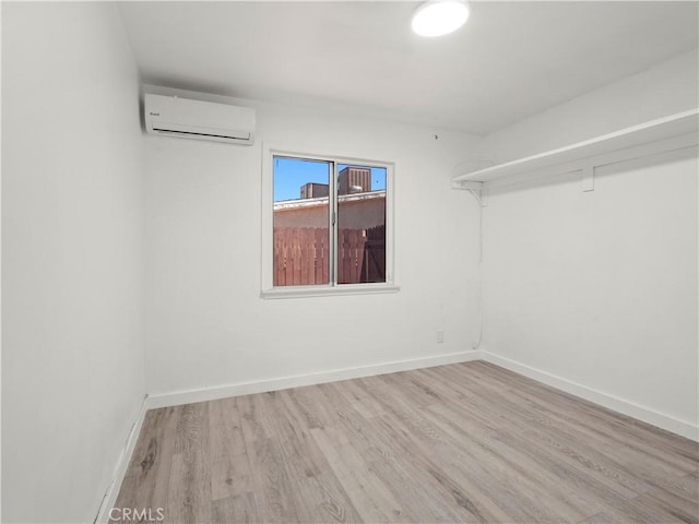 38809 Juniper Tree Rd, Palmdale, CA 93551 - unfurnished room with a wall unit AC, wood finished floors, and baseboards