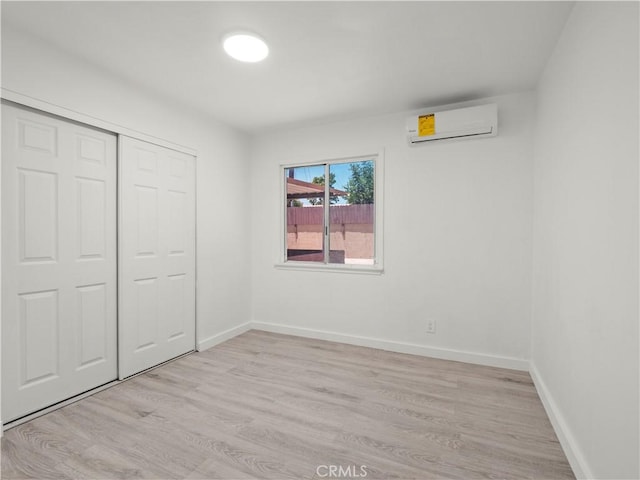 38809 Juniper Tree Rd, Palmdale, CA 93551 - unfurnished bedroom featuring a wall mounted AC, light wood finished floors, a closet, and baseboards