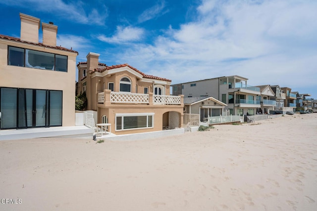 4165 Ocean Dr, Oxnard, CA 93035 - rear view of property with stucco siding, a chimney, a balcony, a residential view, and a tile roof