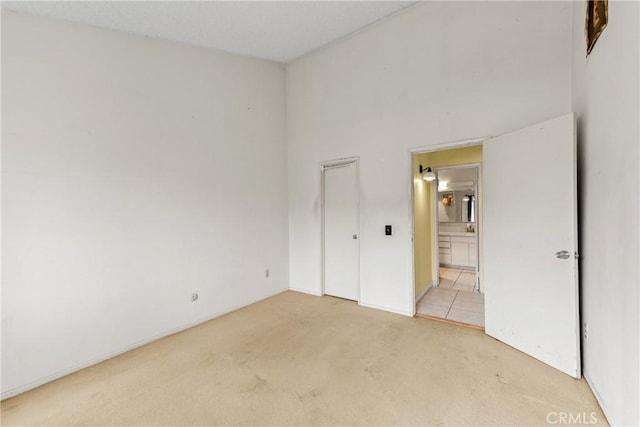 15321 Santa Gertrudes Ave Unit J210, La Mirada, CA 90638 - unfurnished bedroom featuring light carpet, connected bathroom, and a closet